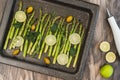 Fresh green asparagus, sliced lemon, olives, rosemary, mint leaves and seasoning close up