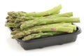 fresh green asparagus tips on a black plastic tray