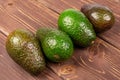 Fresh green avocado on brown wood