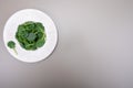 Fresh green baby Spinach leaves, diet and health concept, weight loss, spinach on ceramic plate, copy space Royalty Free Stock Photo