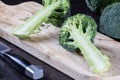 Fresh green broccoli florets on a wooden cutting board with a knife Royalty Free Stock Photo