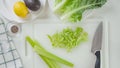 Fresh green celery chopped on cutting board. Celery lettuce salad recipe, ingredients close-up on white background, flat lay Royalty Free Stock Photo