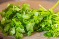 Fresh green cilantro, coriander leaves on wooden surface