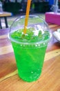 Fresh green cola water and ice in plastic glass.