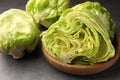 Fresh green cut and whole iceberg lettuce heads on grey table, closeup