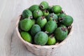 Fresh green feijoa fruits in a basket.