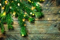 Fresh green fluffy bushy fir tree branches on old plank wood background. Glittering golden garland lights. Christmas New Year Royalty Free Stock Photo