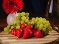 Fresh green grapes and red strawberry on a wooden board, Two champagne flutes and a bottle of champagne without label, Royalty Free Stock Photo