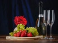 Fresh green grapes and red strawberry on a wooden board, Two champagne flutes and a bottle of champagne without label, Royalty Free Stock Photo