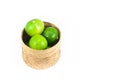 Fresh green limes in the bamboo basket isolated on white background Royalty Free Stock Photo