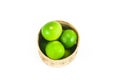 fresh green limes in the bamboo basket isolated on white background Royalty Free Stock Photo