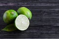 Fresh green limes and half a lime on a wooden background of Royalty Free Stock Photo