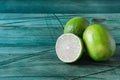 Fresh green limes and half a lime on a wooden background of Royalty Free Stock Photo