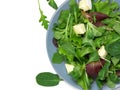 Fresh green mixed salad with spinach, rucola, romaine, lettuce and brie cheese, on white background, top view. Royalty Free Stock Photo