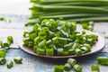 Fresh green onion chopped and lies on a bowl on a background of blue boards