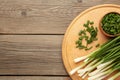 Fresh green onions on a cutting board on grey wooden background. Space for text Royalty Free Stock Photo