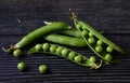 Fresh green pea pod with beans isolated on dark wooden background. Fresh pods of green peas horizontal composition isolated on a Royalty Free Stock Photo