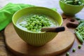 Fresh green pea soup with pea seeds and pea pods around . Selective Focus, Focus on the pea in the middle of the soup Royalty Free Stock Photo