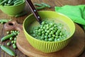 Fresh green pea soup with pea seeds and pea pods around . Selective Focus, Focus on the pea in the middle of the soup Royalty Free Stock Photo