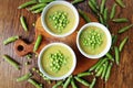 Fresh green pea soup with pea seeds and pea pods around . Selective Focus, Focus on the pea in the middle of the soup. Top view Royalty Free Stock Photo