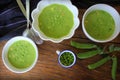 Fresh green pea soup with pea seeds and pea pods around , top view Royalty Free Stock Photo