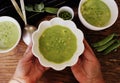 Fresh green pea soup with pea seeds and pea pods around , top view Royalty Free Stock Photo