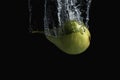 Fresh green pear in water splash isolated on black background. Minimal food concept Royalty Free Stock Photo