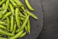 Fresh green peas on black plate. Bright green pea pods. Top view. Legumes vegetables Royalty Free Stock Photo