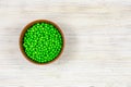 Fresh green peas in a bowl on a white background. View from above. Place for an inscription.