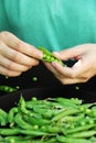 Fresh green peas in a hand on a dark background. Fresh food from the garden. Plant food Royalty Free Stock Photo