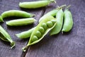 Fresh green peas, just harvest. close up view of opened pod. spring vegetable up view on the wooden background