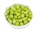 Fresh green peas in a litlle white ceramic bowl. Isolated on white background, close-up, top view Royalty Free Stock Photo