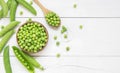 Fresh green peas with pod in bowl and spoon on wooden table Royalty Free Stock Photo