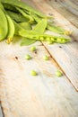 Fresh green peas pods and green peas with sprouts on green wooden background. Concept of healthy eating, fresh vegetables Royalty Free Stock Photo