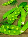 Fresh green peas on wood background. peas, pods and leaves set. Healthy food. Macro shooting.