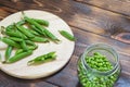 Fresh green peeled peas in glass jar on wooden table