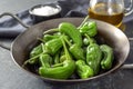 Fresh green pimientos or peppers de padron in an iron pan. Fried in olive oil, and sprinkled with sea salt is a typical tapa meal