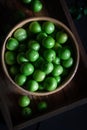 Fresh green plums in bowl on wooden background. Royalty Free Stock Photo