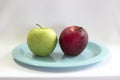 Fresh green & red apple on blue plate. Royalty Free Stock Photo
