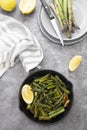 Fresh green roasted asparagus in black iron pan. Healthy, vegan food