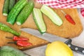 Fresh green sliced cucumbers, chilli, lemon on kitchen wooden cutting board. Cooking vegetable salad Royalty Free Stock Photo