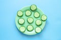 Fresh green slices of cucumbers on a plate. Flat lay composition. Summer freshness and healthy food concept.