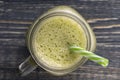 Fresh green smoothie from avocado, kiwi, banana, honey, dill and parsley in glass mug on wooden background, top view. Concept of Royalty Free Stock Photo