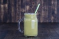 Fresh green smoothie from avocado, kiwi, banana and honey in glass mug on wooden background, closeup. Concept of healthy eating Royalty Free Stock Photo