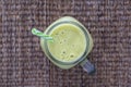 Fresh green smoothie from avocado, kiwi, banana and honey in glass mug on wooden background, closeup. Concept of healthy eating Royalty Free Stock Photo