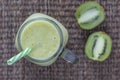 Fresh green smoothie from avocado, kiwi, banana and honey in glass mug on wooden background, closeup. Concept of healthy eating Royalty Free Stock Photo