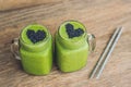 Fresh green smoothie with banana and spinach with heart of sesame seeds. Love for a healthy raw food concept Royalty Free Stock Photo