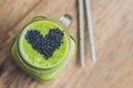 Fresh green smoothie with banana and spinach with heart of sesame seeds. Love for a healthy raw food concept Royalty Free Stock Photo