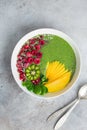 fresh green smoothie bowl with spinach, mango, kiwi and raspberry. Healthy vegan raw food
