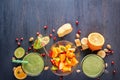 Fresh green smoothies in glass mug fruits, vegetables and fruit salad on a wooden table Royalty Free Stock Photo